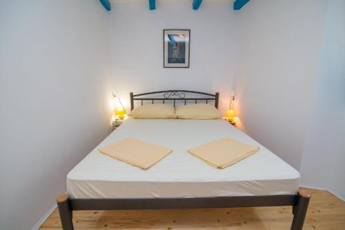 大洛希尼Ferienhaus mit Privatpool für 4 Personen ca 70 qm in Veli Lošinj, Kvarner Bucht Losinj的一间卧室配有一张床,上面有两条毛巾