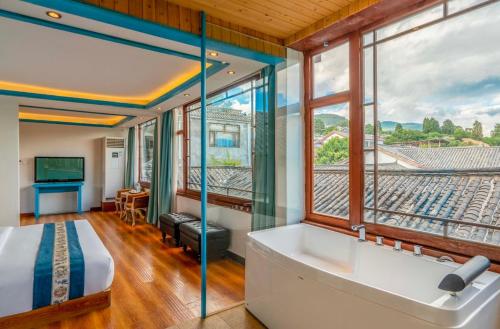 丽江Dream Tour Scenic Inn 梦之旅观景客栈的一间带浴缸和大窗户的卧室