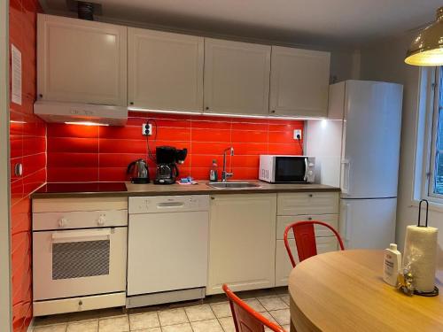 博伦厄Ferienwohnung für 5 Personen ca 60 qm in Borlänge, Mittelschweden See Runn的厨房配有白色橱柜和红色瓷砖