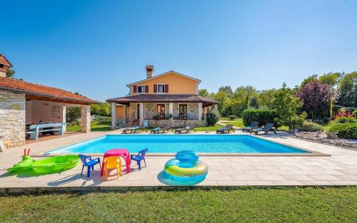 内德斯奇纳Ferienhaus mit Privatpool für 8 Personen ca 200 qm in Vrecari, Istrien Ostküste von Istrien的一个带椅子的游泳池以及一座房子