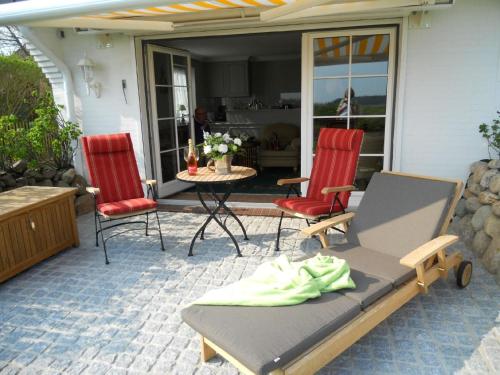曼克玛肖Ferienwohnung für 2 Personen ca 55 qm in Munkmarsch, Nordfriesische Inseln Sylt - a87454的庭院配有两把椅子、一张床和一张桌子