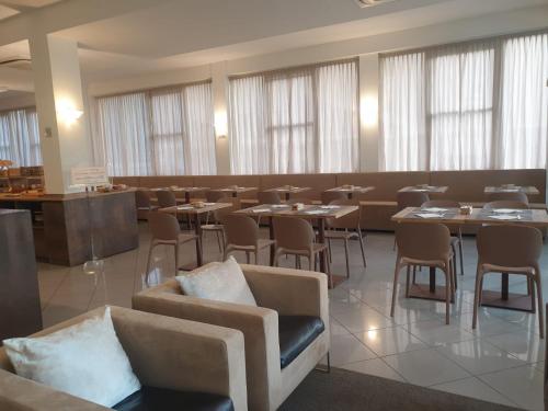 里米尼比安卡贝拉酒店的用餐室设有桌椅和窗户。