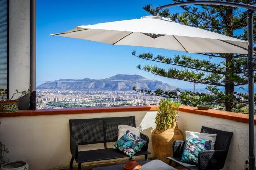 巴勒莫Villa Rosa Bianca的庭院配有遮阳伞、椅子和桌子。