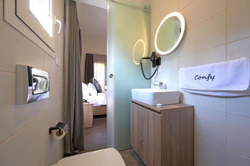 贝鲁特Comfy apart hotel的一间带卫生间、水槽和镜子的浴室