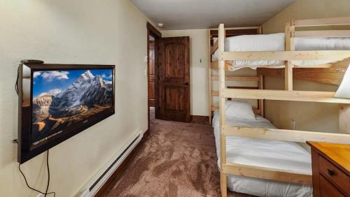布雷肯里奇Cozy 2 BR Condo in Town Walk to Main St Skiing的客房设有两张双层床和电视。