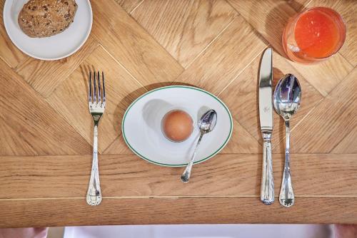 陶尔米纳Palazzo Vecchio Taormina的一张桌子,上面有盘子,上面有鸡蛋和银器
