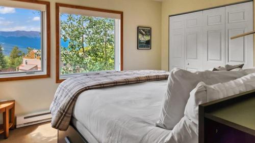 布雷肯里奇Bright Baldy 2BD Near Trailheads的一间卧室设有一张大床和两个窗户。