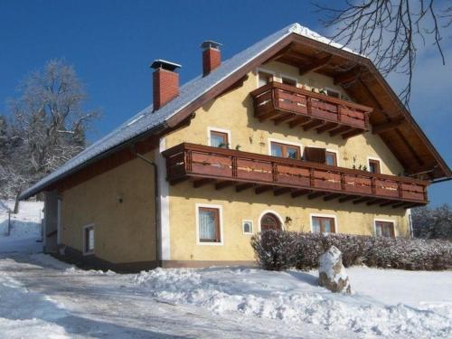 布莱堡Ferienwohnung für 7 Personen ca 70 qm in Bleiburg, Kärnten Unterkärnten的雪边带阳台的房子