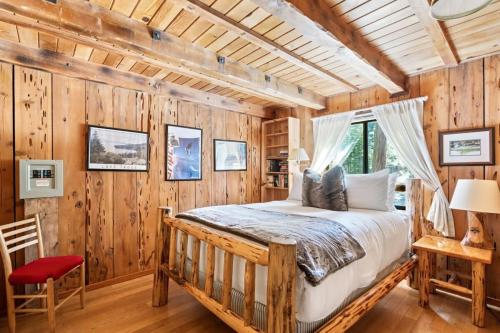 霍姆伍德3BR Mountain Cabin-Near Beach & Slopes的卧室配有一张床铺,位于带木墙的房间内