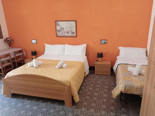 切法卢La locanda的橙色墙壁客房的两张床