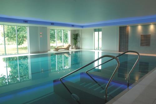 赛伦塞斯特德维尔科茨沃尔德水上公园酒店的一座房子里一个带玻璃地板的游泳池