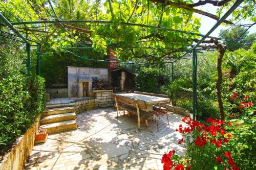 班约勒Ferienwohnung für 6 Personen ca 110 qm in Banjole, Istrien Istrische Riviera的花园内带桌子和壁炉的庭院