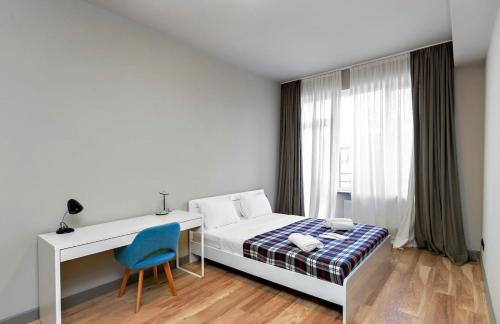 第比利斯Stylish newly renovated 1 BR Apt on the modern Abashidze street的一间卧室配有一张床、一张桌子和一把椅子