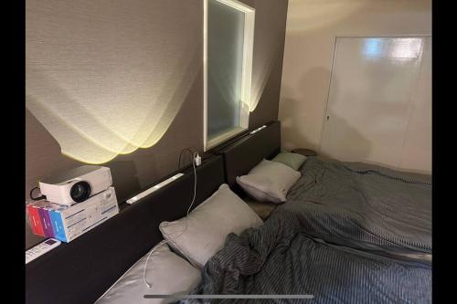 札幌Monster lodge 札幌的一间小卧室,配有床和窗户