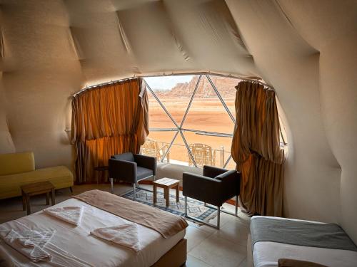 瓦迪拉姆RUM NEPTUNE lUXURY CAMP的一间卧室设有大窗户,享有沙漠美景