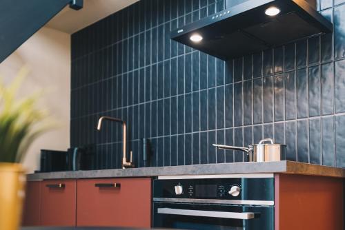 海牙LVM Stays的厨房设有黑色瓷砖墙