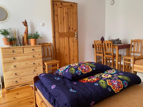 GrodziskApartament Hajstra z ogrodem的一间卧室配有一张床和一个木制梳妆台
