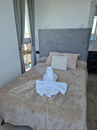 贝尼多姆Cielo de Benidorm的一间卧室配有一张床,床上有浴袍
