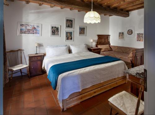 基安蒂格雷夫玻娜赛拉农庄别墅酒店的一间卧室配有一张大床和一把椅子