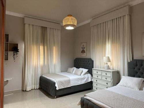 璜多里奥Luxury Village at Juan Dolio.的一间卧室配有两张床和吊灯。