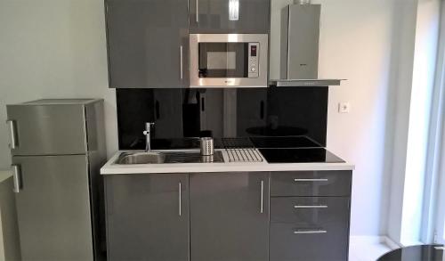 波尔图Covelo Apartment的厨房配有不锈钢冰箱和微波炉。