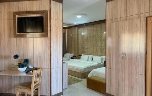 拉希迪耶Hotel Oasis Palace的酒店客房设有两张床和电视。