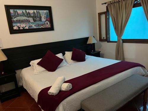 莱瓦镇VILLA LEWANA 2的一间卧室配有一张带红色和白色枕头的大床