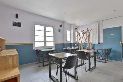 卡布勒通杜章酒店的一间拥有蓝色墙壁和桌椅的用餐室