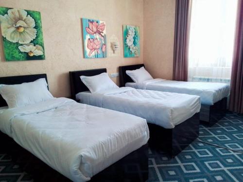 希瓦Al-Qal`a的酒店客房,配有两张带白色床单的床