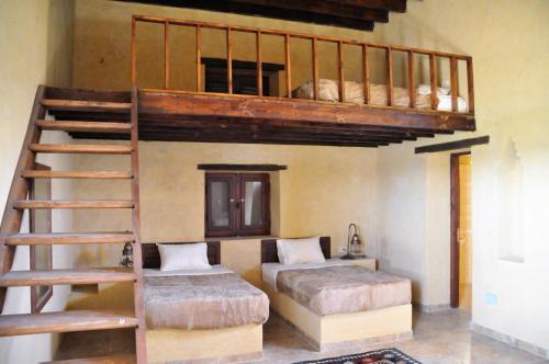 Az ZabūEl Beyt Farmhotel的一间卧室设有两张双层床和梯子