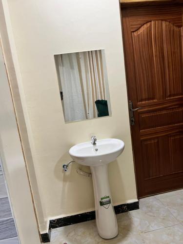 基苏木Art’s Suites的浴室设有白色水槽和镜子