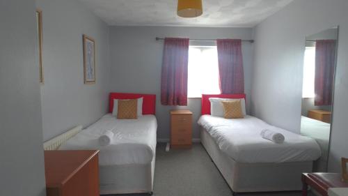 Houghton RegisEddiwick House - Huku Kwetu Dunstable -Spacious 3 Bedroom House- Sleeps 6 - Suitable & Affordable Group Accommodation - Business Travellers的一间小卧室,配有两张床和窗户