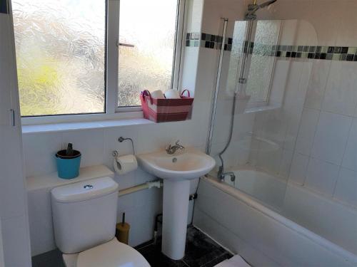 Houghton RegisEddiwick House - Huku Kwetu Dunstable -Spacious 3 Bedroom House- Sleeps 6 - Suitable & Affordable Group Accommodation - Business Travellers的浴室配有卫生间、盥洗盆和浴缸。