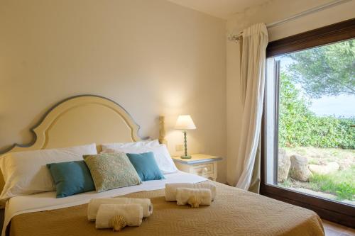 利斯西亚迪维卡[Piscina-Giardino] Casa 3 Minuti da Porto Cervo的一间卧室设有一张大床和大窗户