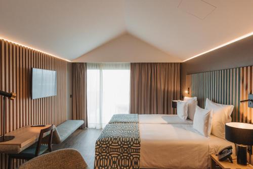 Areia LargaPico Terramar & SPA的酒店客房设有一张大床和一张书桌。