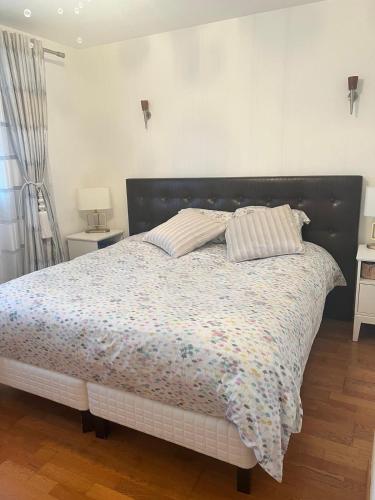 隆瑞莫Maisons d'hôte à la campagne Parisienne的一间卧室配有一张带花卉棉被的床