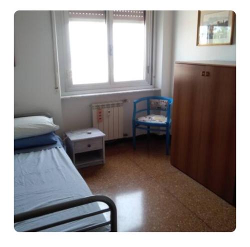 热那亚Terrazza sul mare citra 1666的卧室配有床、椅子和窗户。
