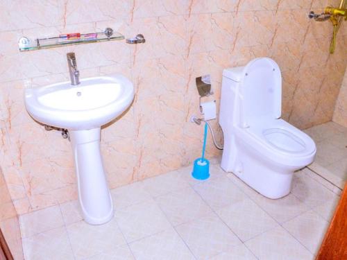 基加利KEZA Home的浴室配有白色卫生间和盥洗盆。
