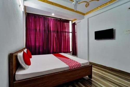 巴特那Hotel Mahal Inn的一间卧室配有一张带红色窗帘的床