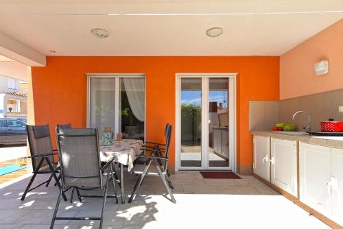 巴尔巴里加Ferienhaus mit Privatpool für 6 Personen ca 80 qm in Barbariga, Istrien Istrische Riviera的厨房设有橙色墙壁和桌椅