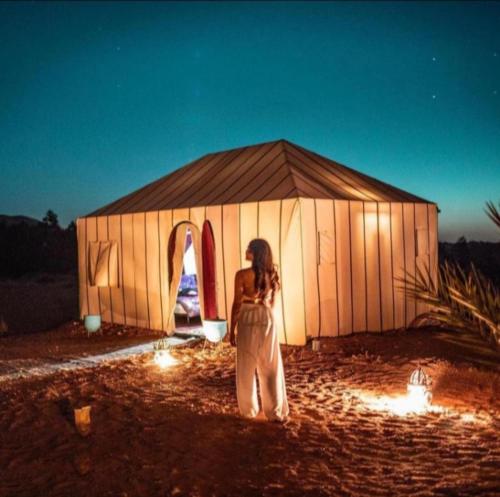 梅尔祖卡Merzouga luxurious Camps的站在大帐篷前的妇女