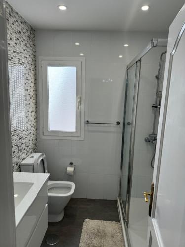 科拉雷侯Apartamento Corralejo的白色的浴室设有卫生间和窗户。