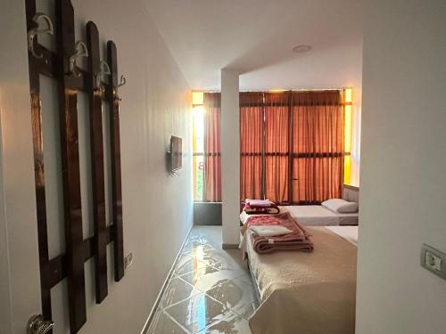PeshkopiHotel Kristali的酒店客房设有两张床和窗户。