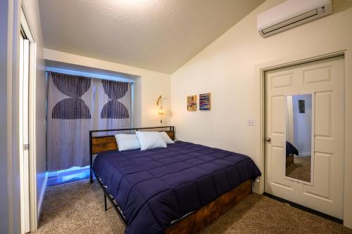 尤金Blue House - private 2 bed, 2 bath home with garage的一间卧室配有一张带紫色棉被的床