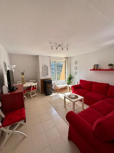 BrañaviejaApartamento en estación de esquí y montaña alto campoo的客厅配有红色的沙发和桌子