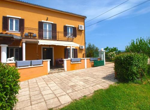 瓦图拉Ferienwohnung für 6 Personen ca 75 qm in Valtura, Istrien Südküste von Istrien的黄色的房子设有阳台和庭院