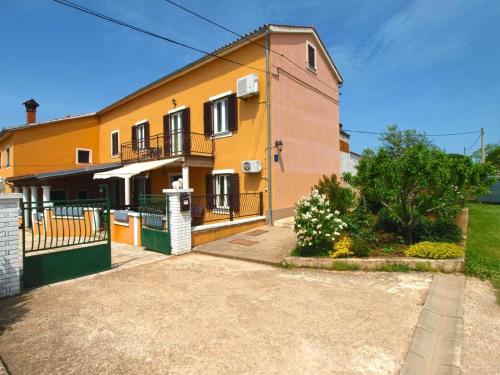 瓦图拉Ferienwohnung für 6 Personen ca 75 qm in Valtura, Istrien Südküste von Istrien的前面有车道的大型黄色房屋