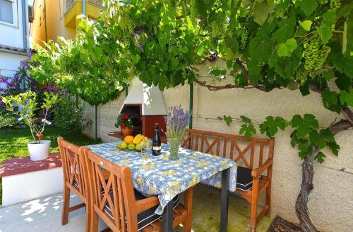 ValbandonFerienwohnung für 4 Personen ca 42 qm in Fažana-Surida, Istrien Istrische Riviera - b55463的树下一张桌子,上面有水果