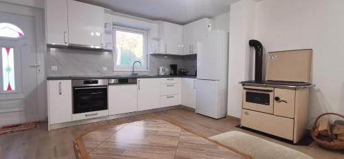 利夫诺Fortuna的厨房配有白色橱柜和炉灶烤箱。
