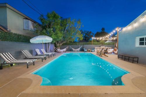 洛杉矶Angel&Rose Universal Hollywood Heated Pool House King Bed的后院的游泳池配有椅子和遮阳伞